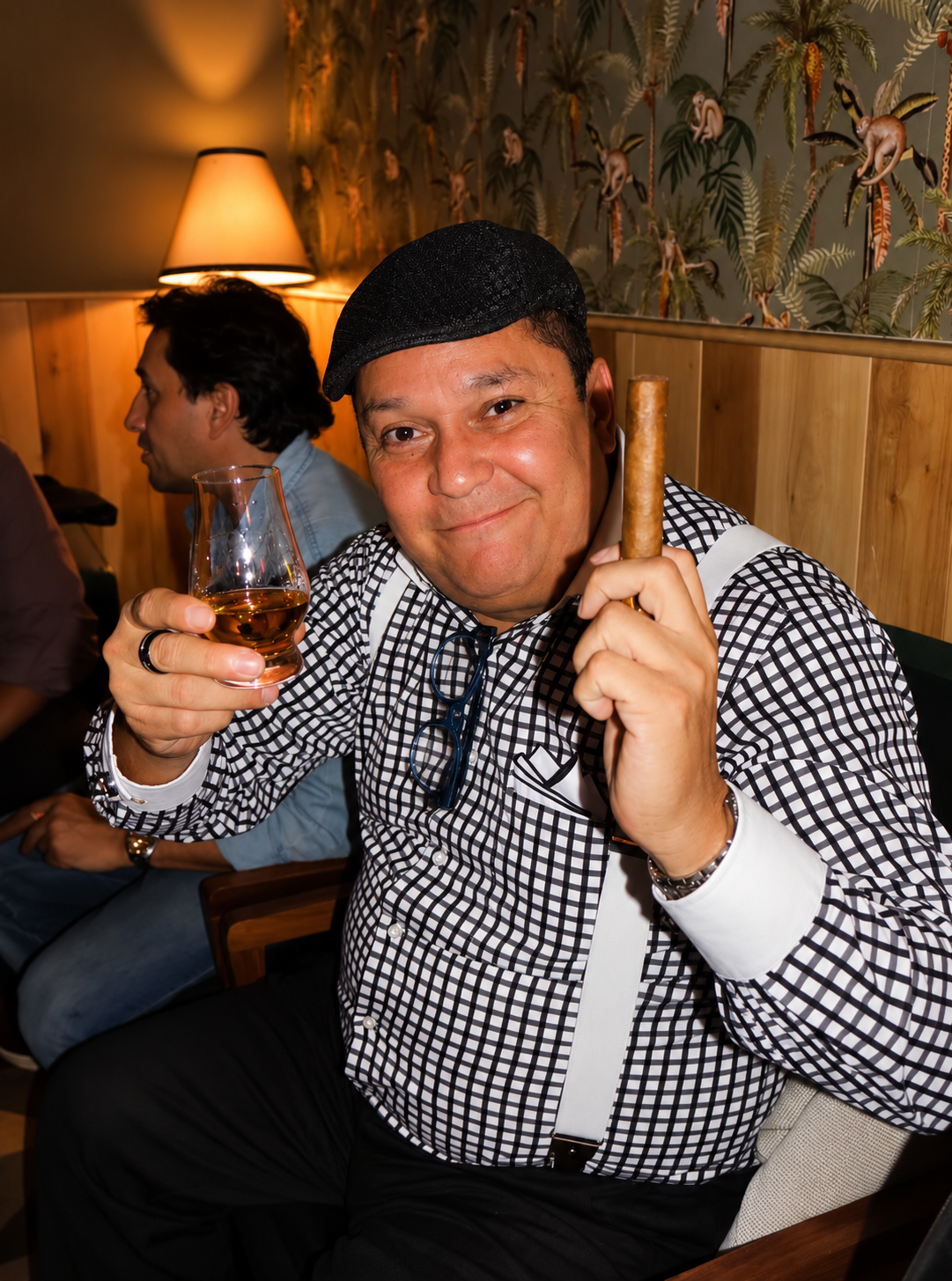 Miembro del club brindando con whisky y puro